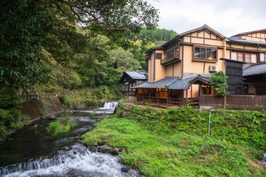 Japonya, Kumamoto 'daki Kurokawa kasabasındaki Ryokan Otel binalarının yanında çağlayan dere nehri. Kyushu 'daki cennet gibi sıcak bahar kasabasının ünlü seyahat yeri..