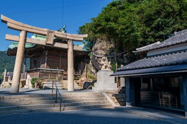 Mekari Tapınağı 'na giden Torii kapısı mavi gökyüzüne karşı, Kitakyushu, Fukuoka, Japonya. Kanmon Askılık Köprüsü 'nün Kyushu ve Honshu Adası' ndan geçişini izlemek için ünlü bir yer..