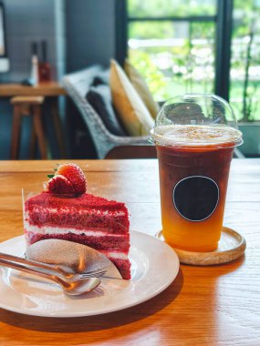 Kafe masasında kırmızı kadife kek ve portakallı Americano kahvesi. Yiyecek ve tatlı endüstri. Sağlıksız beslenme tarzı.