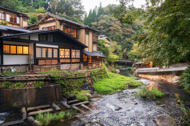 Japonya 'nın Kumamoto kentindeki Kurokawa kasabasında çağlayan dere nehri boyunca uzanan Japon ryokan oteli. Kyushu 'daki cennet gibi sıcak bahar kasabasının ünlü seyahat yeri..
