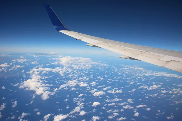 Vleugel van het vliegtuig boven witte wolken — Stockfoto