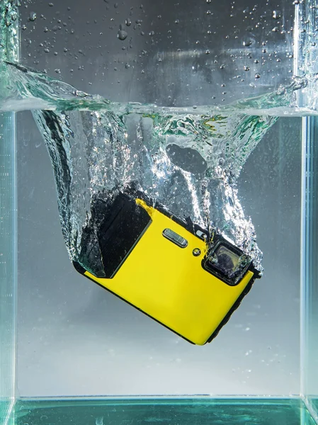 Câmera caiu na água do recipiente com respingo — Fotografia de Stock