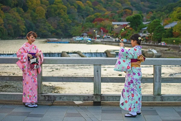 Japanese girls taking photo at Togetsukyo bridge — Stock Photo, Image