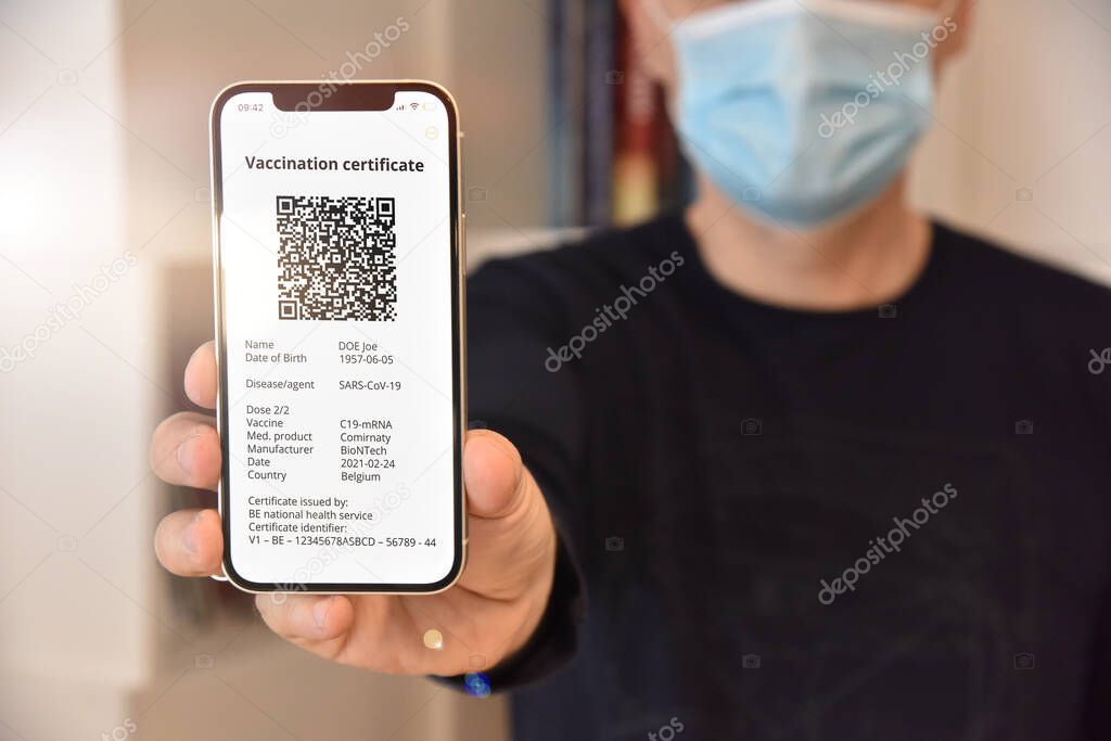 Man holding mobile phone with digital certificate of vaccination against Covid-19, a negative PCR test or recovery from Covid-19. Travel concept during coronavirus pandemic.