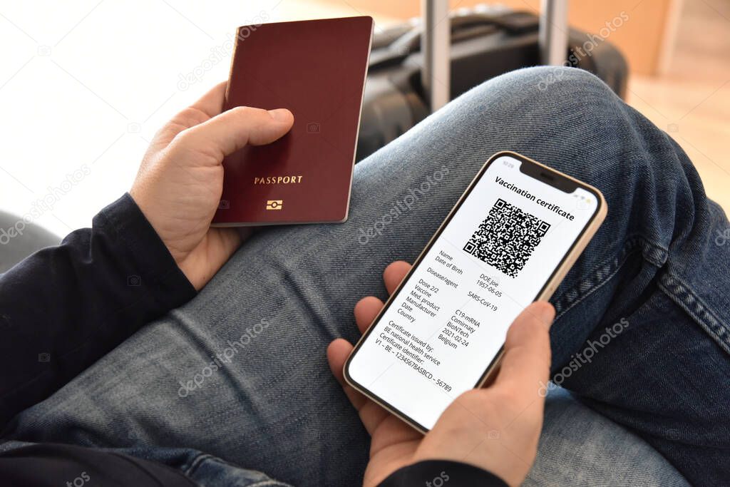Man holding passport and mobile phone with digital certificate of vaccination against Covid-19, a negative PCR test or recovery from Covid-19. Travel concept during coronavirus pandemic.