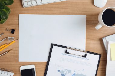 Office workspace with copy space, stationary, computer, smartphone, supplies, coffee cup, top view