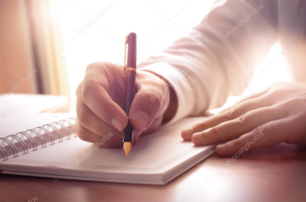 Businessman writing on a notebook