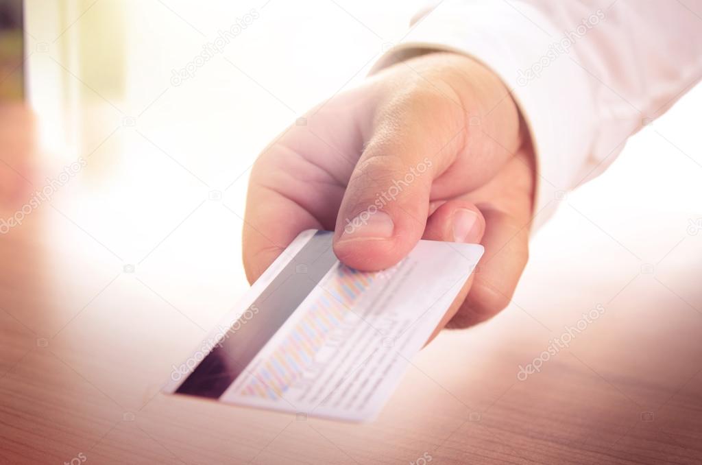 Man's hand holding a credit card