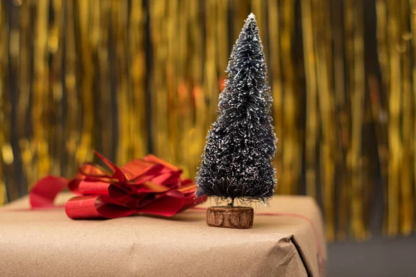 Kleine Kerstboom Een Cadeautje Met Gouden Achtergrond Kerstversiering — Stockfoto