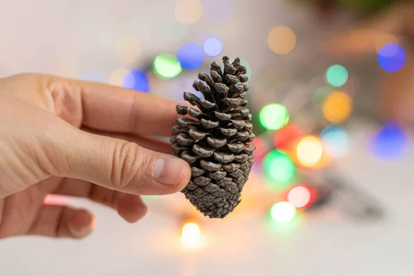 Mano Mujer Sosteniendo Pequeño Cono Pino Con Luces Navidad Bokeh —  Fotos de Stock