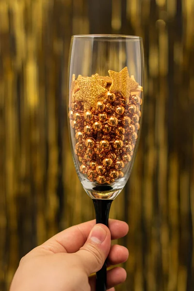 Mulher Mão Segurando Copo Com Estrelas Douradas Bolas Fundo Dourado — Fotografia de Stock