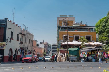 CUERNAVACA, MORELOS, MEXICO - 20 Şubat 2026: Calle Hidalgo 'nun renkli koloni mimarisini gösteren Cuernavaca, Morelos şehir merkezinde yoğun bir öğleden sonra. Görüntü, yerel sokak satıcısı Casa Hidalgo restoranının ikonik sarı cephesini gösteriyor.