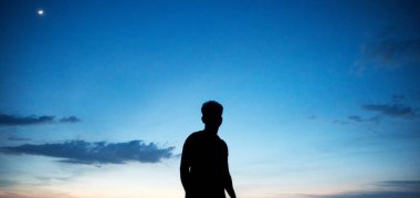 Sahildeki insanların silueti.