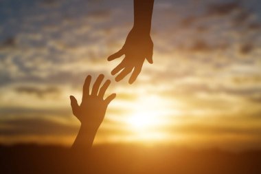 Gün batımında birbirimize yardım etme, umut ve destek olma silueti..