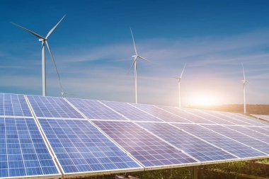 Mavi gökyüzü arka planında rüzgar türbinleri olan güneş panelleri. Fotovoltaik, alternatif elektrik kaynağı. sürdürülebilir kaynaklar kavramı.