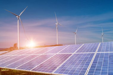 Mavi gökyüzü arka planında rüzgar türbinleri olan güneş panelleri. Fotovoltaik, alternatif elektrik kaynağı. sürdürülebilir kaynaklar kavramı.