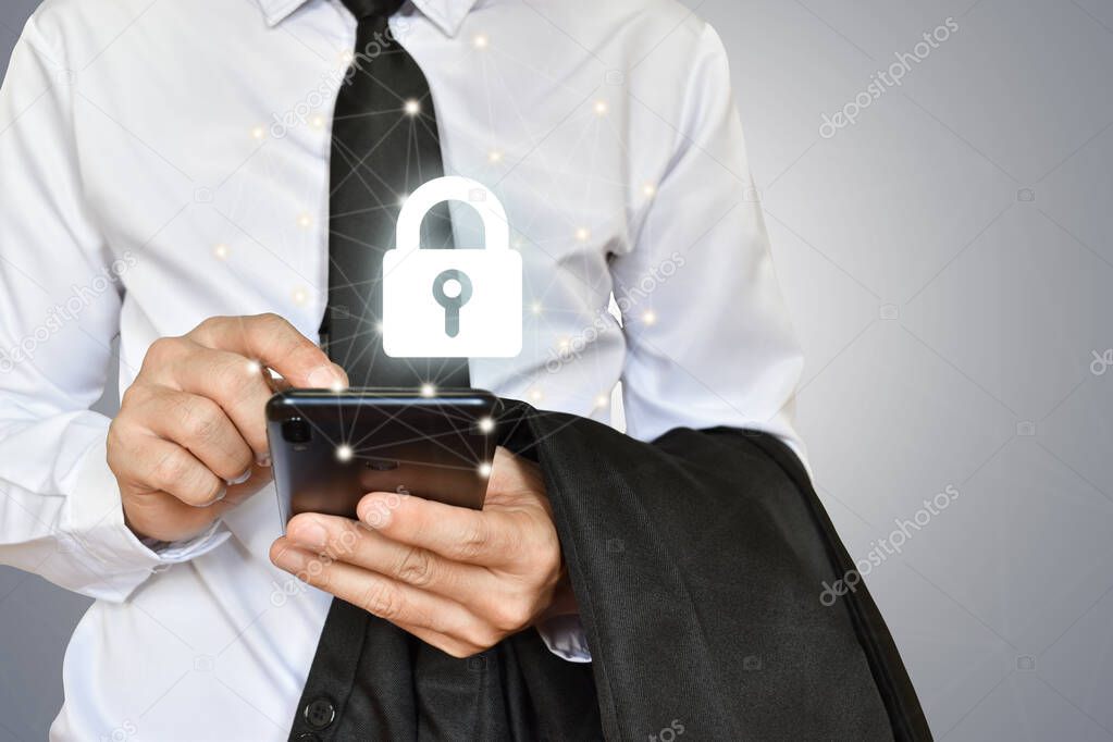 Businessman holding mobile phone with shield lock. Cyber security data protection and information technology network concept.