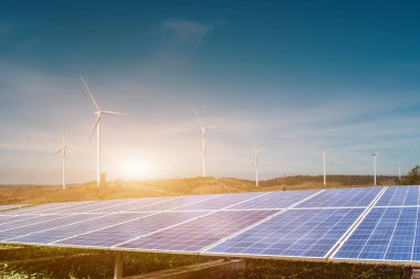 Mavi gökyüzü arka planında rüzgar türbinleri olan güneş panelleri. Fotovoltaik, alternatif elektrik kaynağı. sürdürülebilir kaynaklar kavramı.