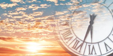 Günbatımı gökyüzünde iki kat saat görüntüsü. Zaman geçişi kavramı.