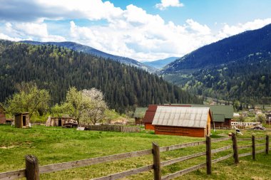 Ukrayna Karpatlarının manzarası, bir nehir akar, dağlar, yamaçtaki ahşap kulübeler
