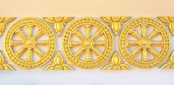 Золотое литьевое колесо в тайском стиле на стене храма — стоковое фото