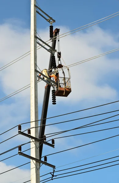 Electrician repairing wire on electric power pole — Stock Photo, Image