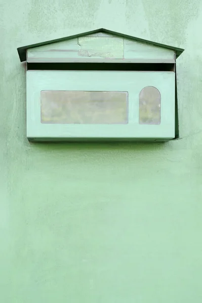 Zielona skrzynka pocztowa na zielonej ścianie — Zdjęcie stockowe