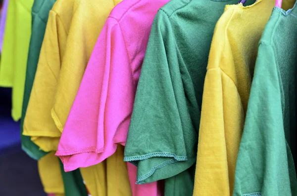 T-shirt colorida em cabides — Fotografia de Stock