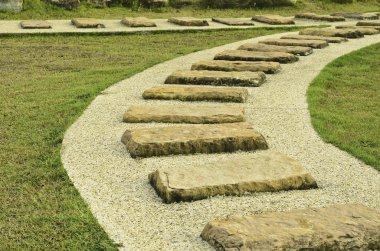 Taş yolları yeşil çim ile parkta yürümek 