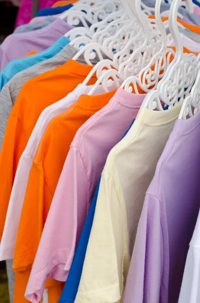 T-shirt colorida em cabides — Fotografia de Stock