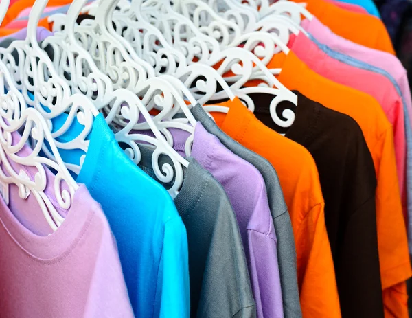 T-shirt colorida em cabides — Fotografia de Stock