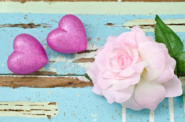 粉红色的心和粉红玫瑰的又脏又臭淡蓝色木背景 — 图库照片