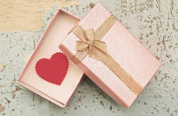 Red heart in gift box on grunge wood background in vintage style — Stock Photo, Image