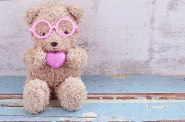 Schöne Bärenpuppe mit rosa Brille und rosa Herz — Stockfoto