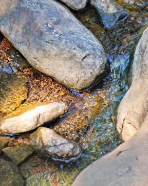 Büyük kaya parçalarından oluşan bir dere dolaşır..