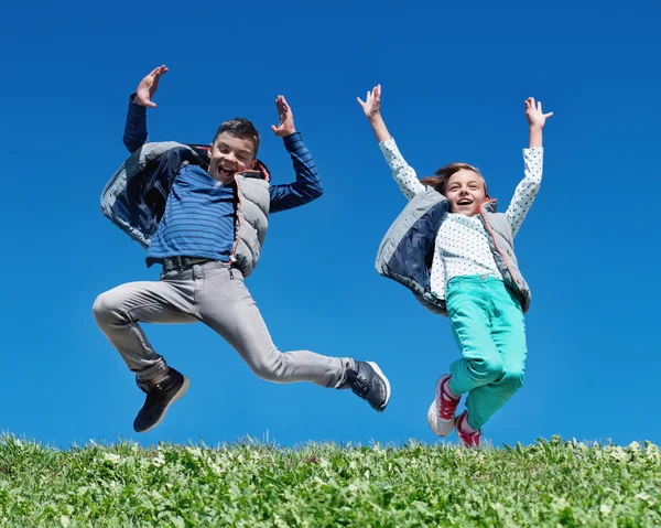 Szczęśliwe dzieci skoki na łące — Zdjęcie stockowe