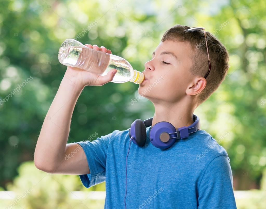 Teen boy drinking water Stock Photo by ©VaLiza 114884958