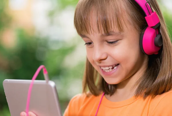 Menina com tablet e fones de ouvido — Fotografia de Stock