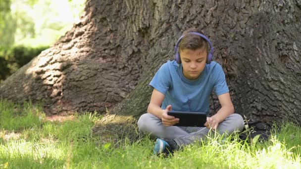 Jongen met tablet op park — Stockvideo