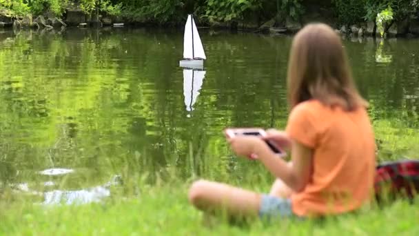 Flicka med avlägsen kontrollerade båt — Stockvideo