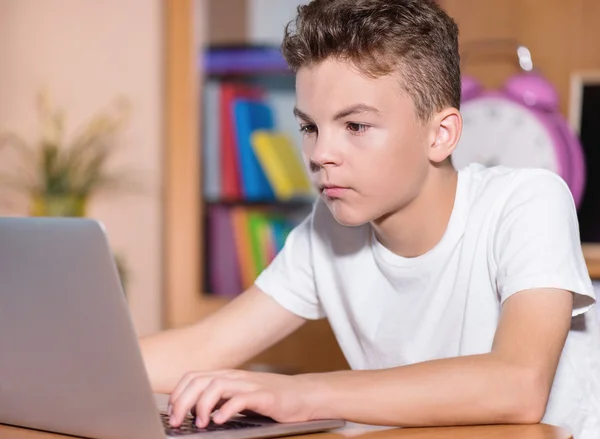Tiener jongen die op laptop werkt — Stockfoto