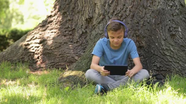 Boy with tablet at park — Stock Video