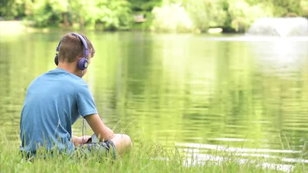 Adolescent garçon au bord du lac — Video