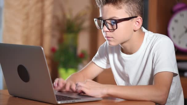 Tiener jongen die op laptop werkt — Stockvideo