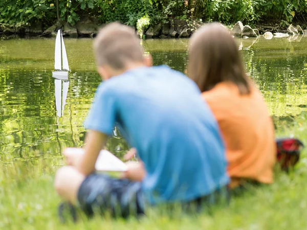 Barn med avlägsen kontrollerade båt — Stockfoto