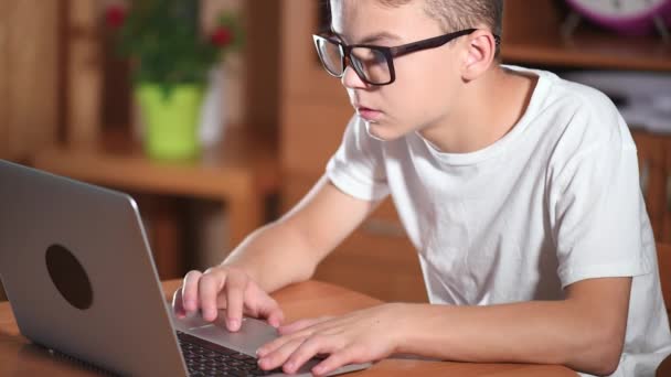 Хлопчик-підліток працює на ноутбуці — стокове відео