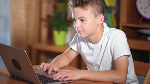Мальчик-подросток работает на ноутбуке — стоковое видео