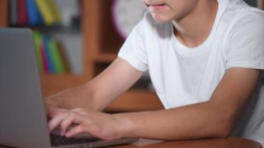 Dizüstü bilgisayarda çalışan bir genç çocuk