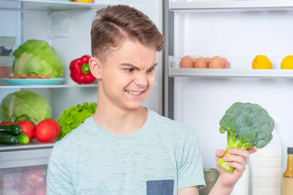 Мальчик с едой возле холодильника Стоковое Изображение