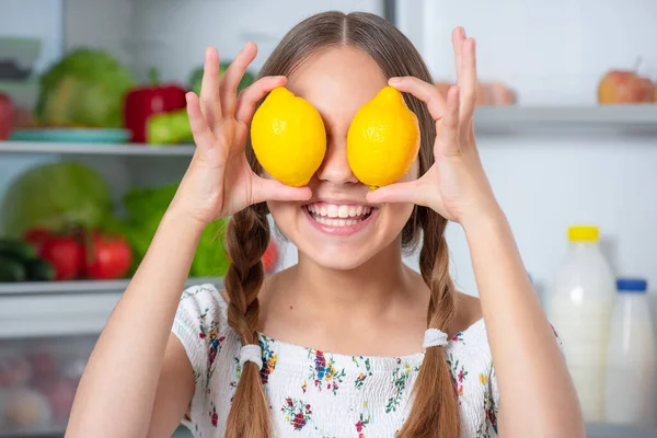 Chica con comida cerca de nevera Fotos de stock